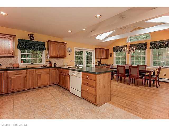 357 Plains Road Milford, CT 06461 - Photo 1 of 1 a kitchen with stainless steel appliances kitchen island granite countertop a stove a sink a dining table and chairs