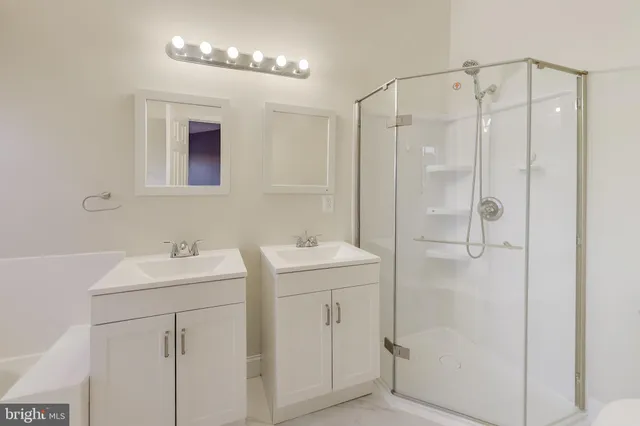 a bathroom with a sink mirror and shower