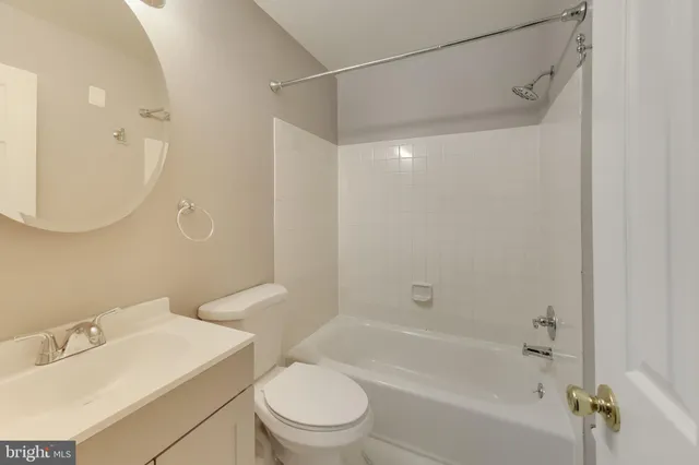 a bathroom with a bathtub shower sink vanity and toilet
