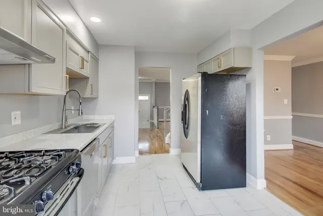 a kitchen with stainless steel appliances granite countertop a refrigerator and a sink