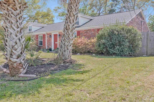 a view of a yard in front of a house with large trees