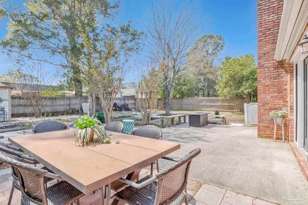 a view of a backyard with table and chairs and potted plants