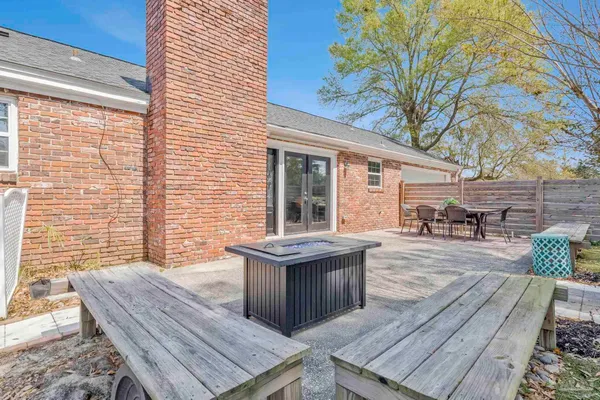 a view of a patio with table and chairs with wooden floor and fence