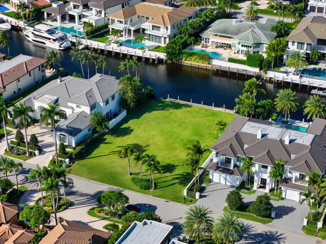an aerial view of residential houses with outdoor space and lake view