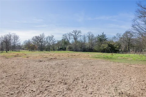 a view of a field with trees in background