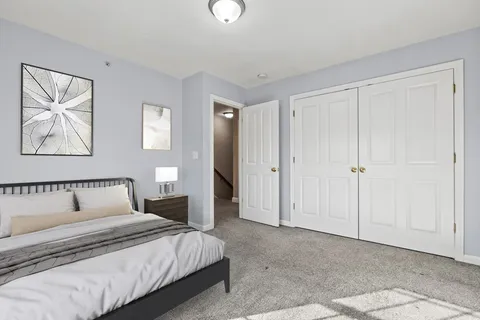 a bedroom with a bed and a painting on the wall