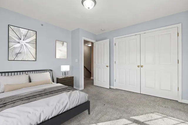 a bedroom with a bed and a painting on the wall