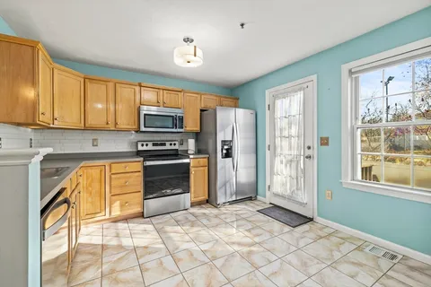 a kitchen with stainless steel appliances granite countertop a refrigerator and a stove top oven