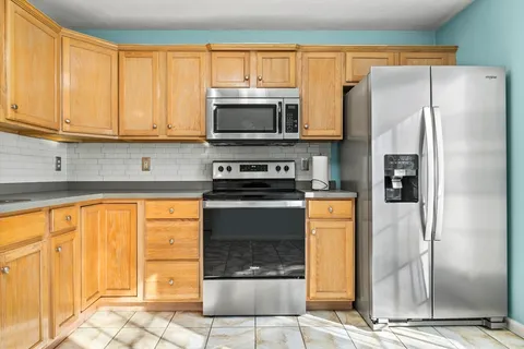a kitchen with stainless steel appliances granite countertop a refrigerator stove and cabinets
