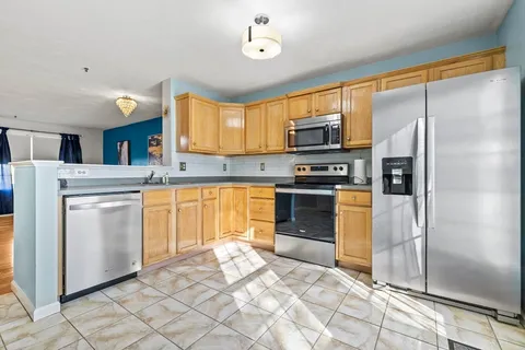 a kitchen with stainless steel appliances granite countertop a stove a sink and a refrigerator