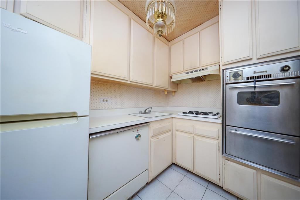 8901 Shore Road, Unit 7B Brooklyn, NY 11209 - Photo 9 of 12 a kitchen with white cabinets and white appliances