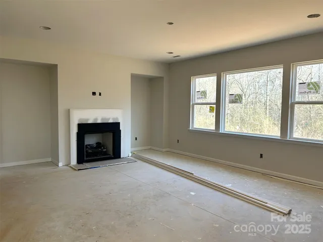 a living room with fireplace furniture and a large window