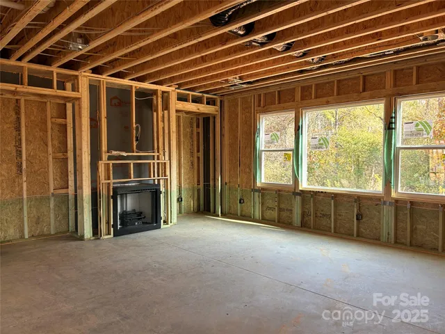 a view of an empty room with a fireplace and a window