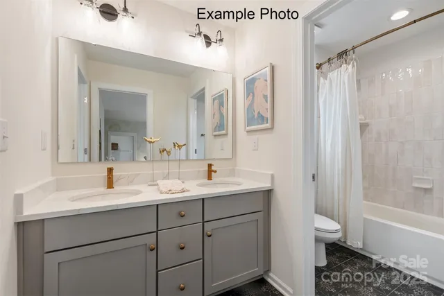 a bath tub sitting next to a white toilet and a shower curtain