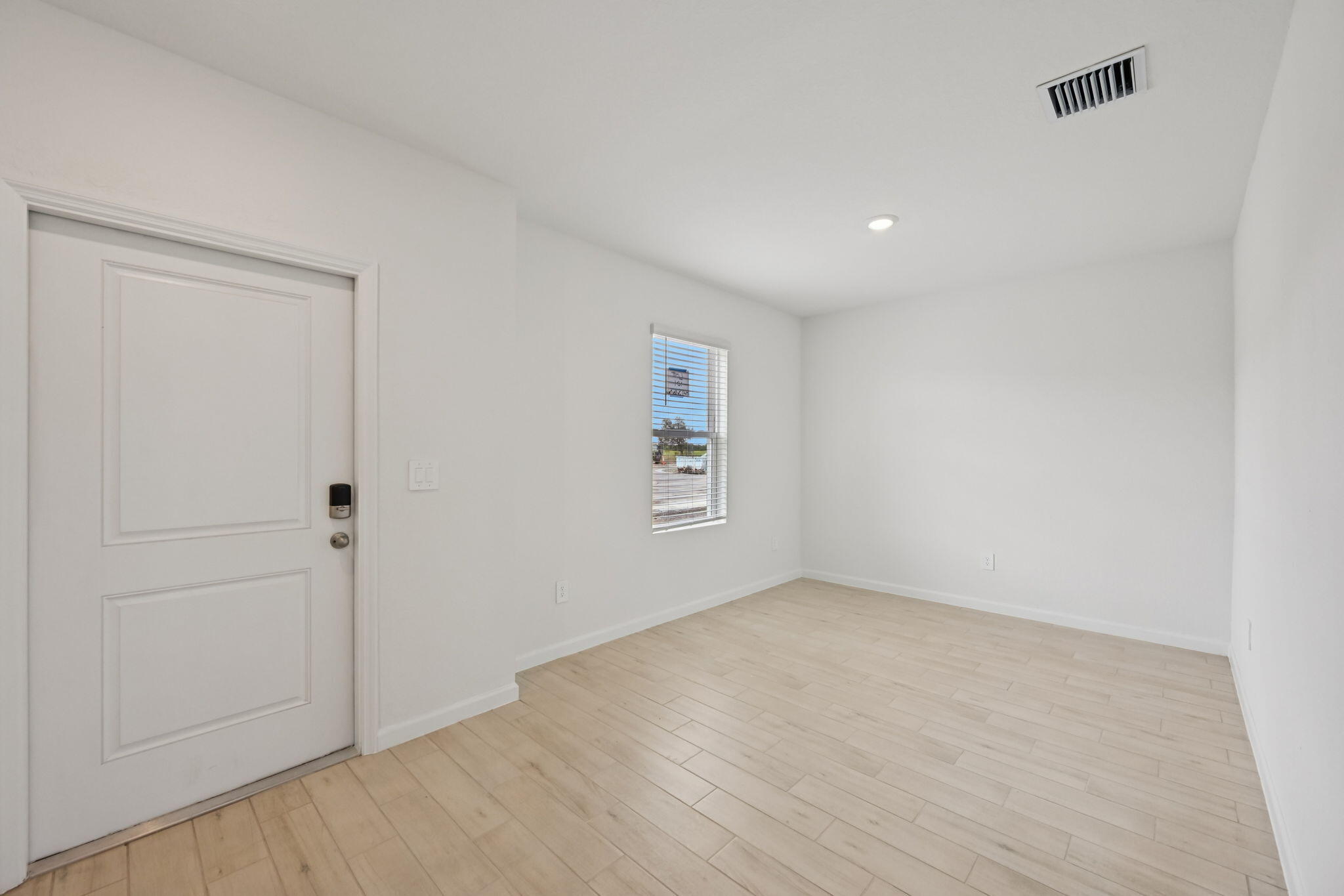 14211 Southwest New Dawn Road Indiantown, FL 34956 - Photo 7 of 37 an empty room with wooden floor and windows