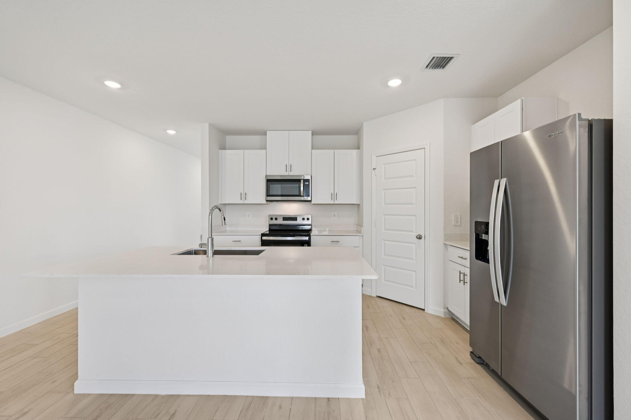 14211 Southwest New Dawn Road Indiantown, FL 34956 - Photo 10 of 37 a kitchen with stainless steel appliances a refrigerator and a stove top oven