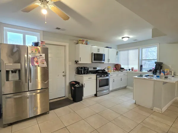a kitchen with white cabinets and white appliances