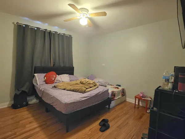 a bedroom with a bed and wooden floor