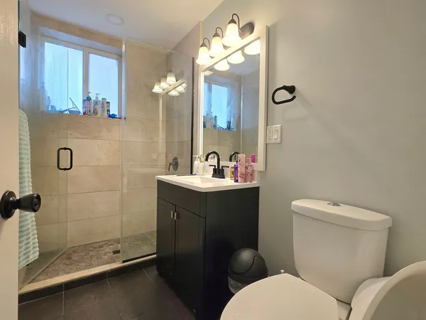 a bathroom with a toilet a sink and mirror