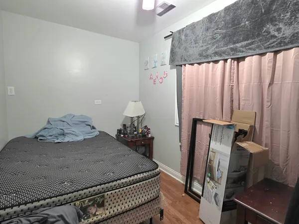 a bedroom with bed and wooden floor