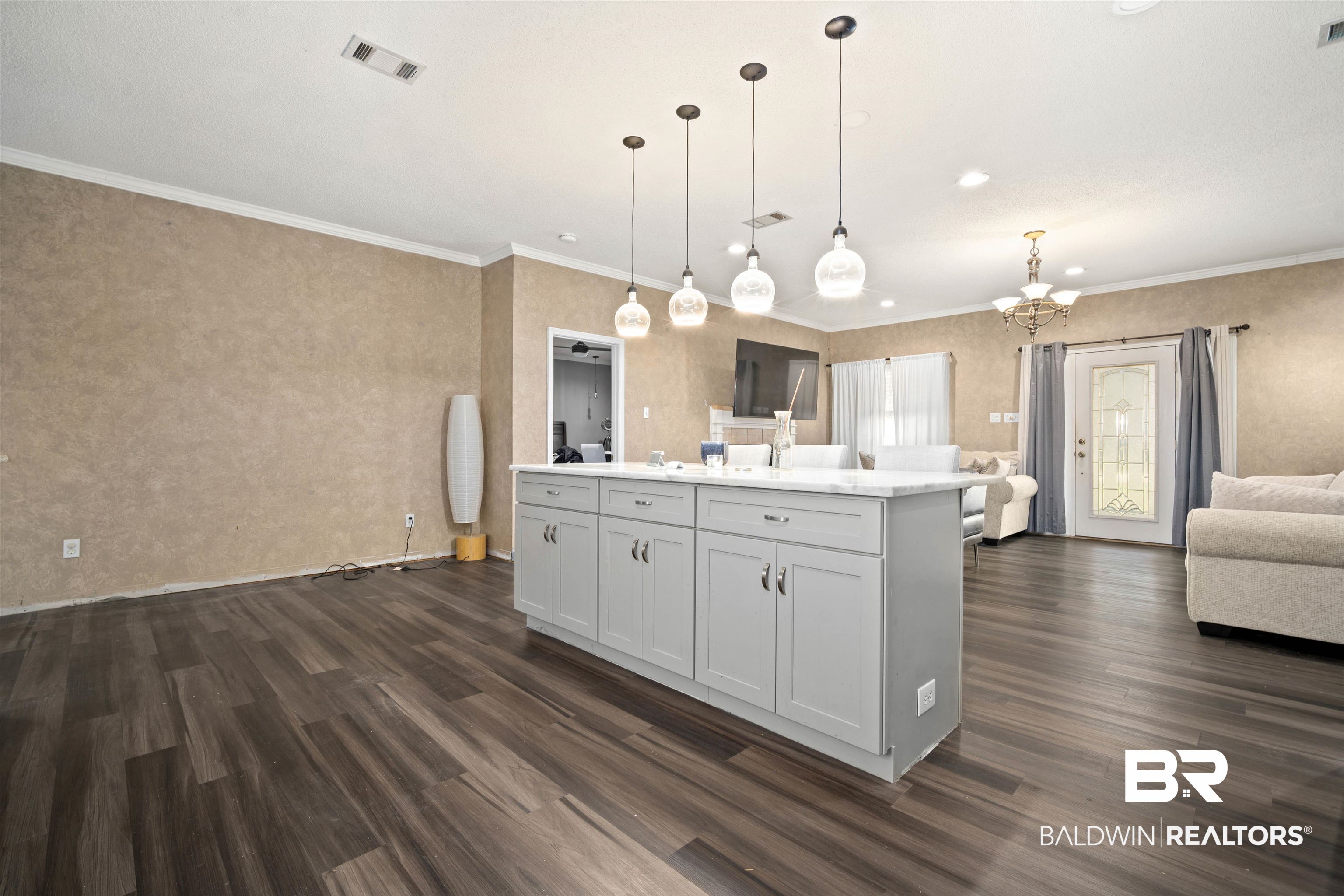1609 Repoll Road Mobile, AL 36695 - Photo 22 of 22 Kitchen featuring open floor plan, ornamental molding, a kitchen island, decorative light fixtures, and dark wood-style floors
