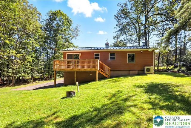a backyard of a house with swimming pool and tree