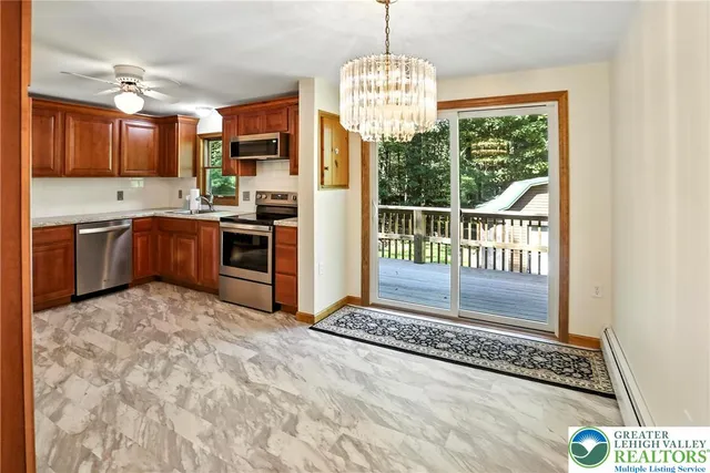 a kitchen with stainless steel appliances granite countertop a stove top oven cabinetry a chimney and a refrigerator