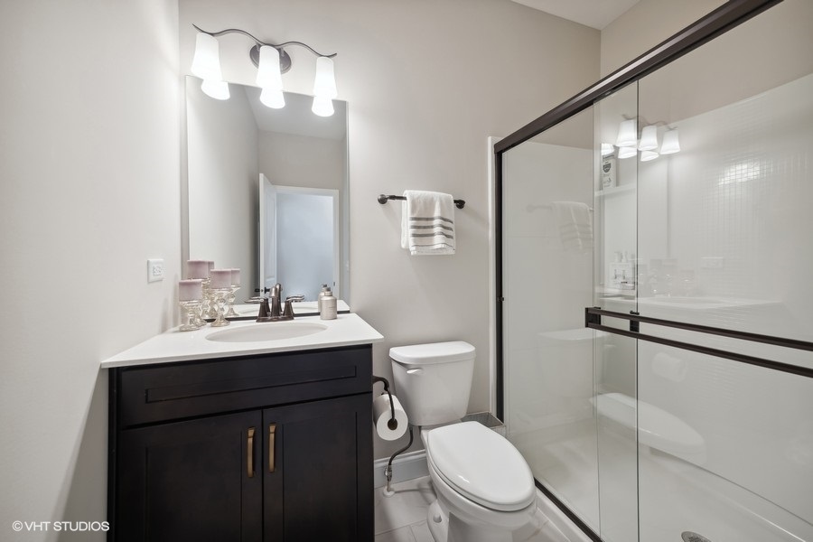 780 Treeline Drive Algonquin, IL 60102 - Photo 16 of 24 a bathroom with a toilet a sink a mirror and a shower