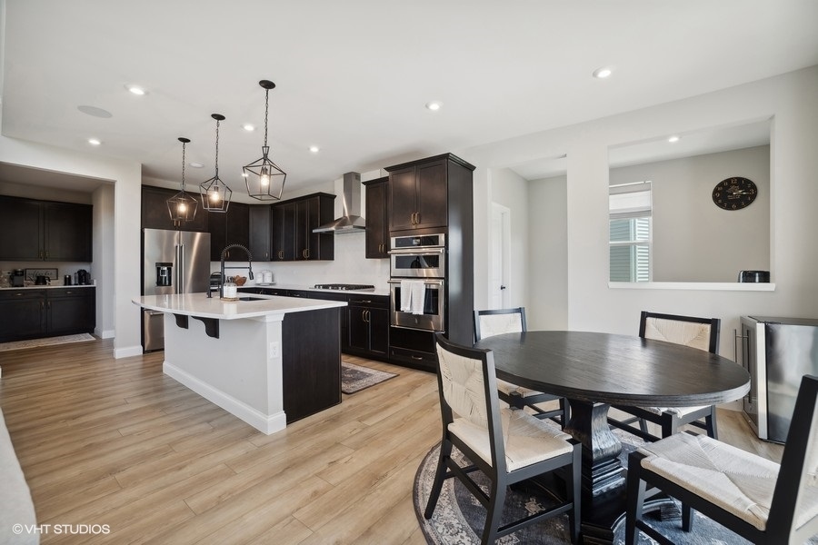 780 Treeline Drive Algonquin, IL 60102 - Photo 5 of 24 a kitchen with stainless steel appliances a dining table chairs stove and refrigerator