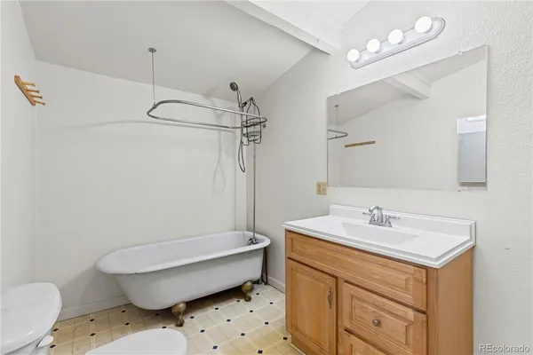 a bathroom with a sink toilet vanity and tub
