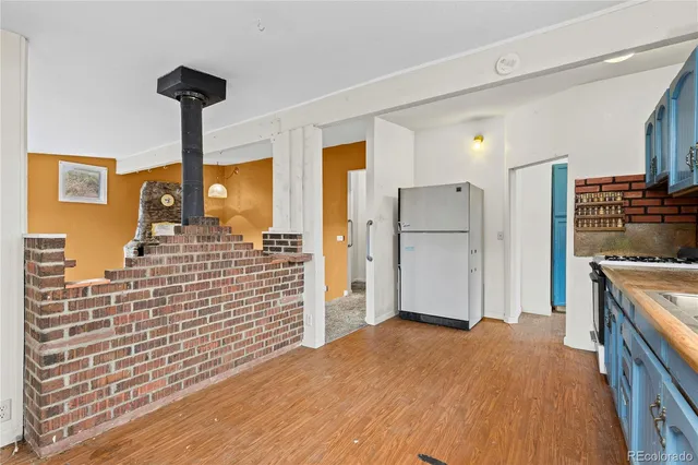 a view of kitchen with refrigerator cabinets and wooden floor