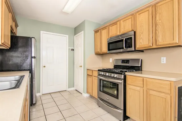 a kitchen with stainless steel appliances granite countertop a stove a microwave and a refrigerator