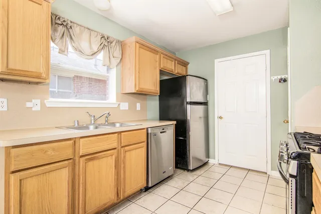 a kitchen with a refrigerator sink and cabinets