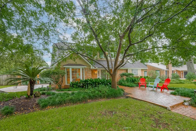 a front view of a house with a yard and trees