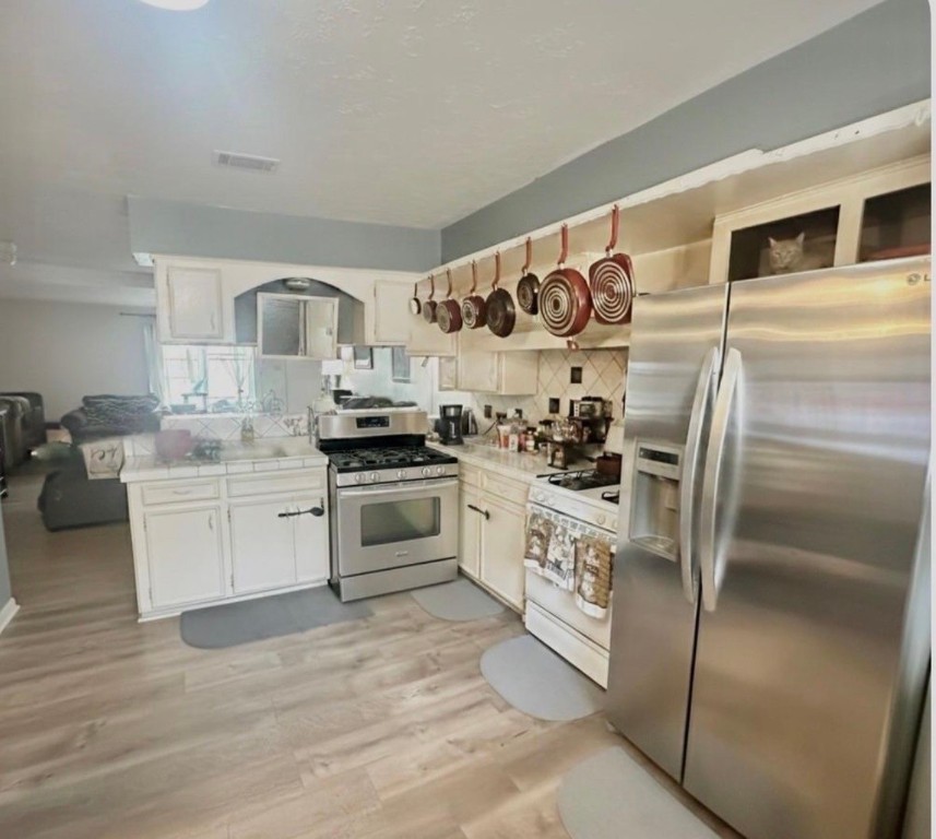 705 Phyllis Court Conroe, TX 77303 - Photo 2 of 17 a kitchen with granite countertop stainless steel appliances and white cabinets