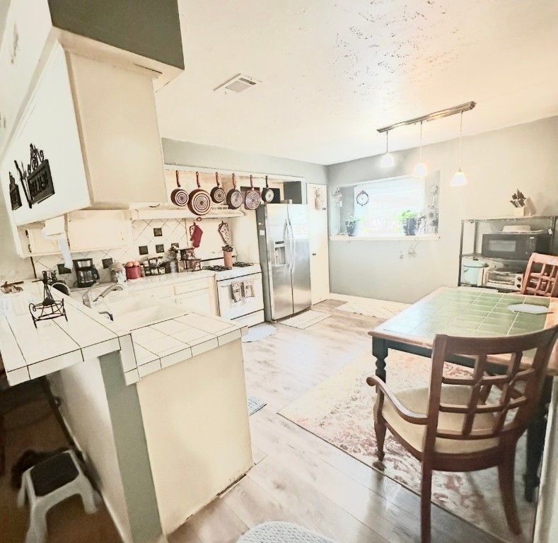 705 Phyllis Court Conroe, TX 77303 - Photo 5 of 17 a dining room with furniture and a kitchen view