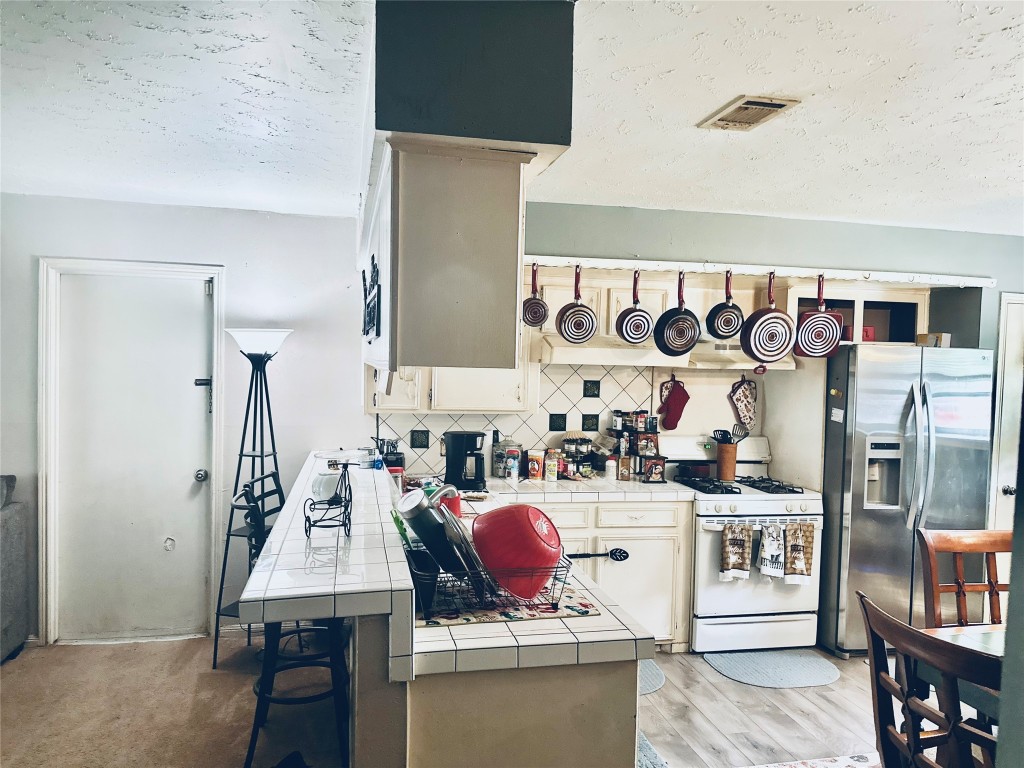 705 Phyllis Court Conroe, TX 77303 - Photo 6 of 17 a kitchen with stainless steel appliances kitchen island granite countertop a sink and cabinets