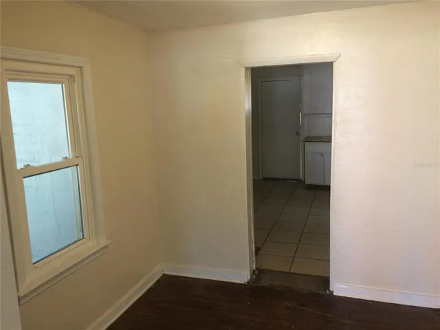 an empty room with wooden floor and entrance