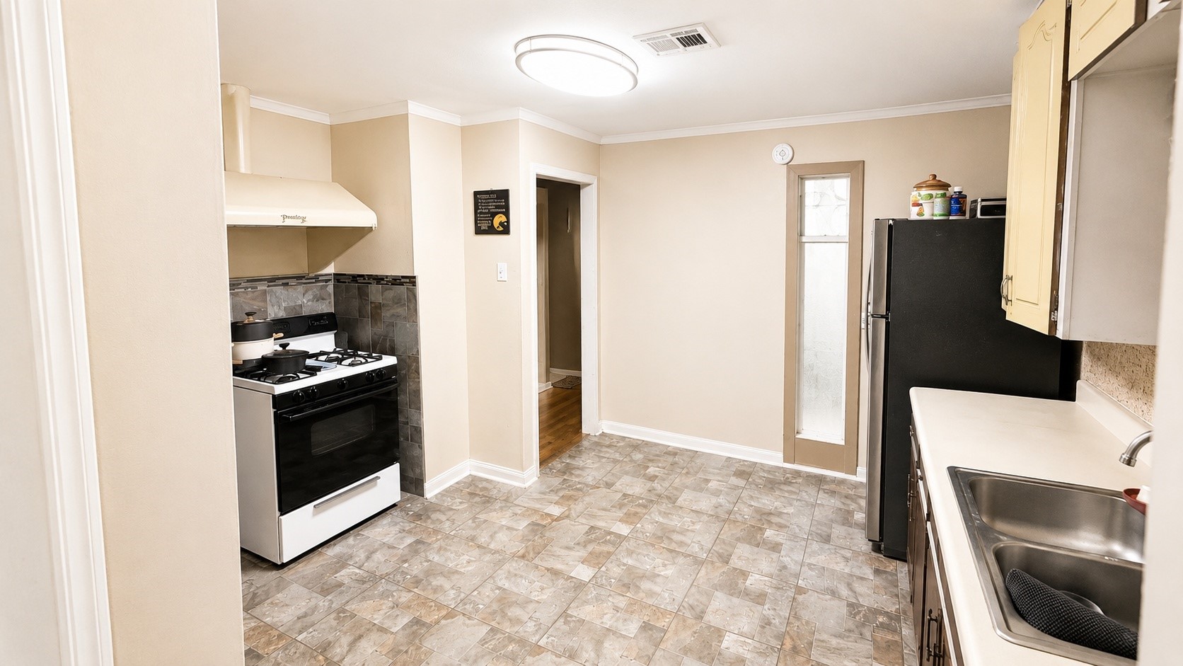 7622 Azalea Street Houston, TX 77023 - Photo 10 of 10 Bright kitchen with ample cabinet storage, durable flooring, and a functional layout perfect for everyday living.