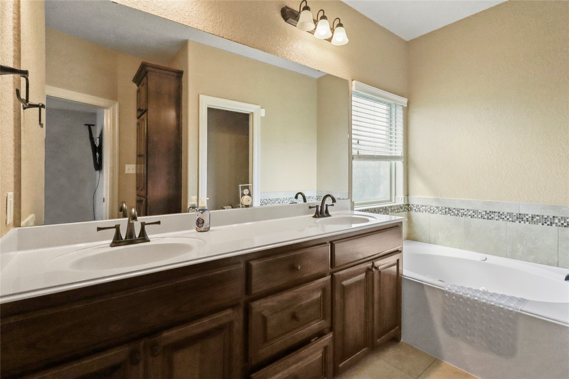 1012 Rosewood Lane Angleton, TX 77515 - Photo 17 of 21 a bathroom with a tub double sink and mirror