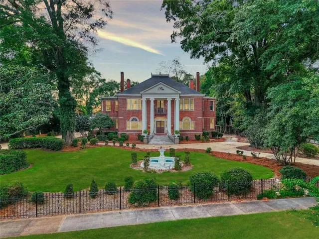 a front view of a house with swimming pool and garden
