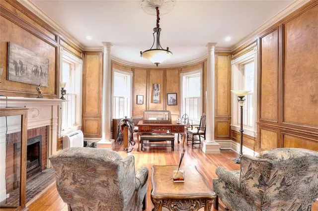 a living room with hard wood floor furniture and a chandelier