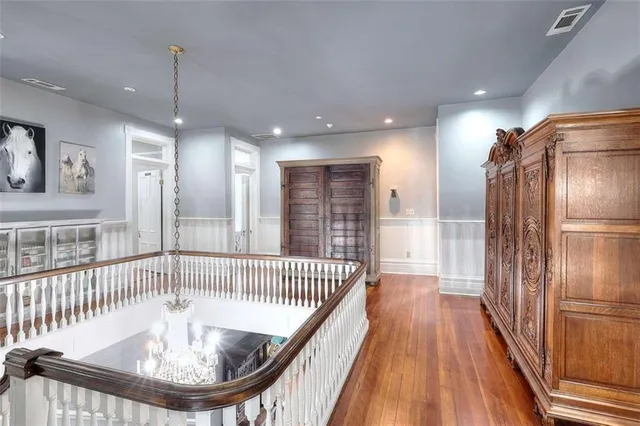 an empty room with wooden floor fireplace and windows