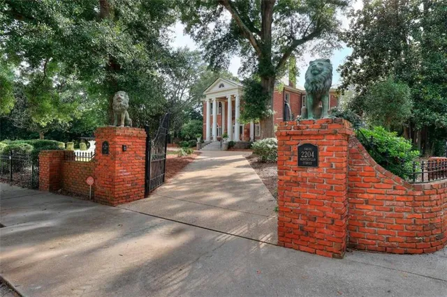 a front view of a house with a yard and trees
