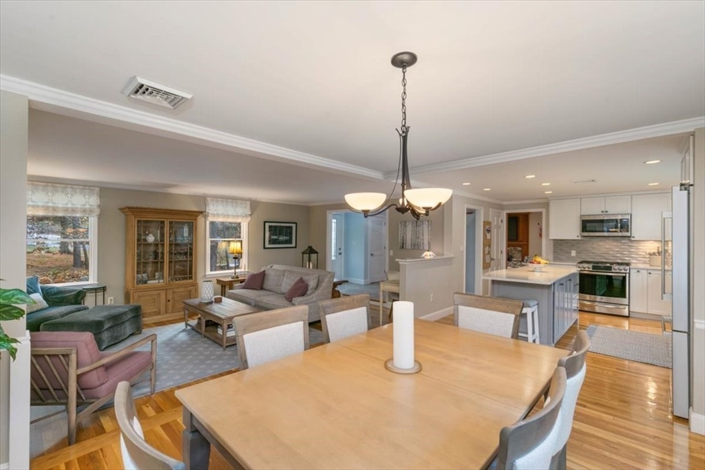 50 Stonecleave Road Boxford, MA 01921 - Photo 12 of 42 a view of a dining room and livingroom with furniture wooden floor a chandelier