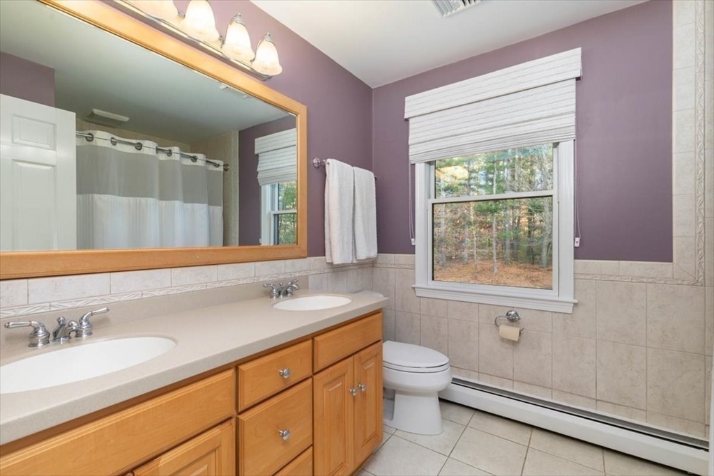 50 Stonecleave Road Boxford, MA 01921 - Photo 29 of 42 a bathroom with a granite countertop sink a toilet a mirror and a window