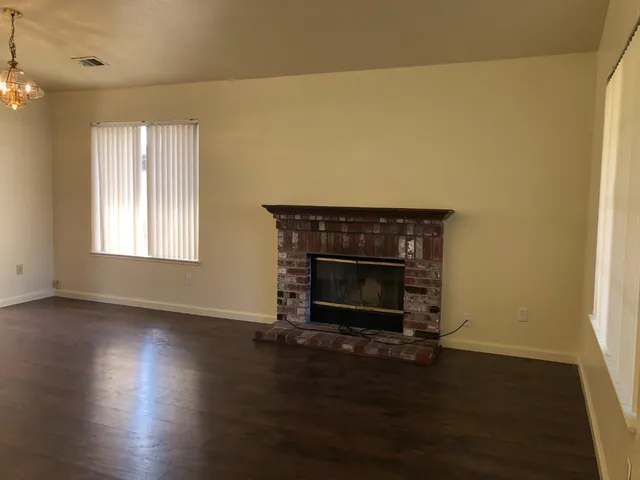 an empty room with wooden floor and fireplace