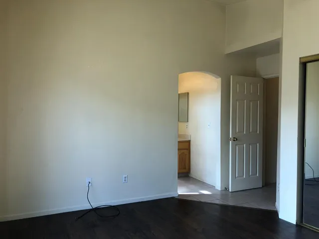 an empty room with wooden floor and closet