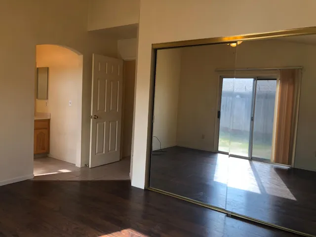 an empty room with wooden floor and closet