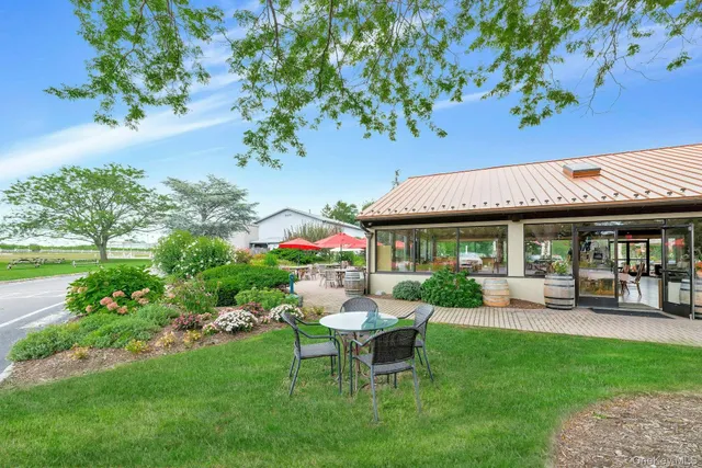 a view of a patio with table and chairs potted plants and a large tree